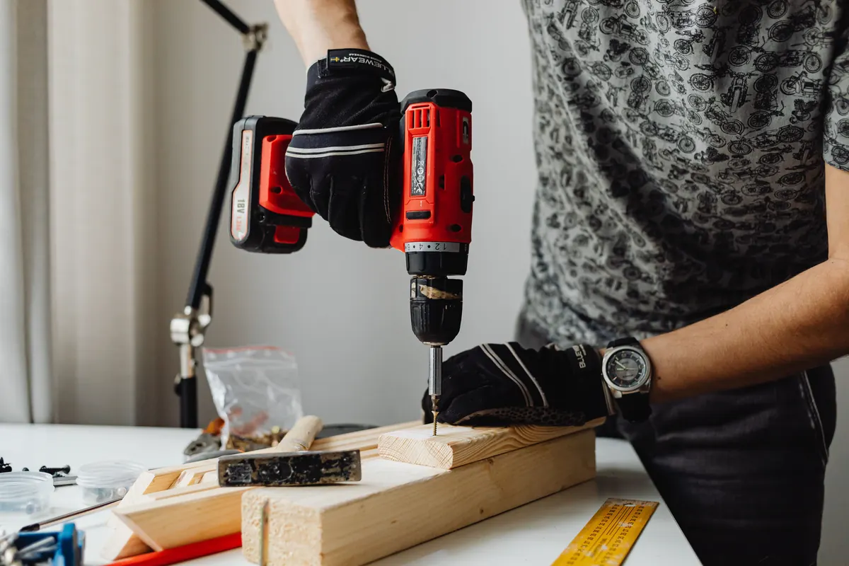 Carpenter using a power drill to join timber on a joinery project