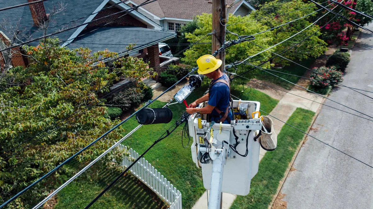 Electrician working safely at height on an overhead power line installation