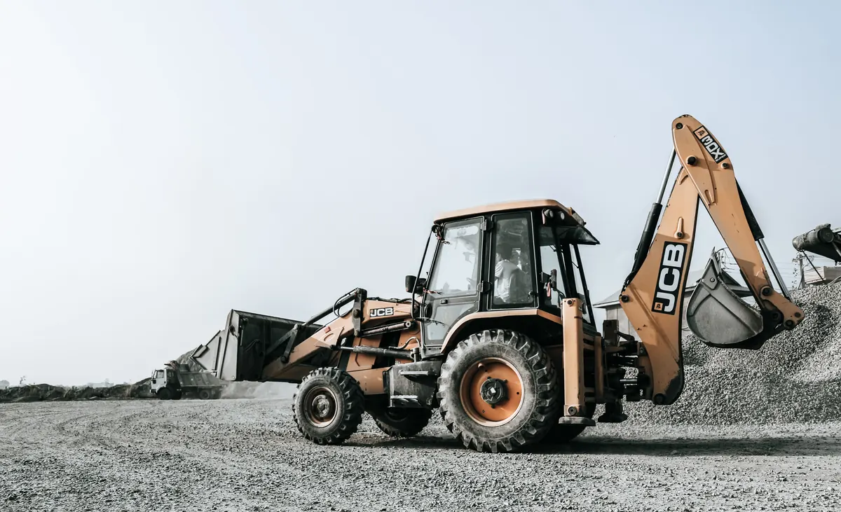 Excavator carrying out groundworks and external works on a construction site
